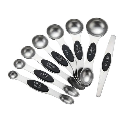 Set of stainless steel measuring spoons with black measurement markings on a light gray background