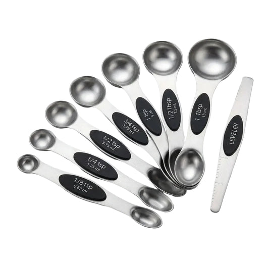Set of stainless steel measuring spoons with black measurement markings on a light gray background