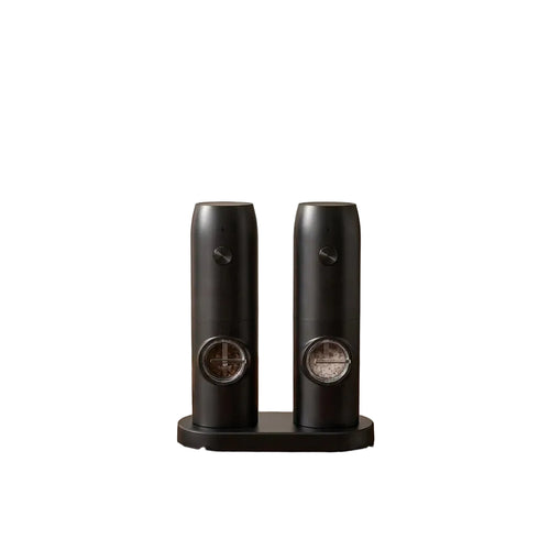 Two black ceramic grinders on a wooden surface withDOMISANA branding.